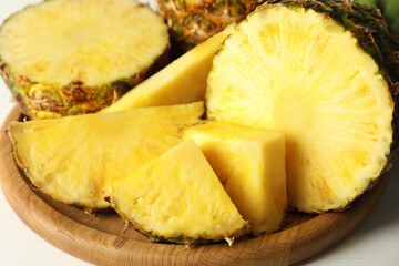Cut fresh ripe pineapple on white table, closeup
