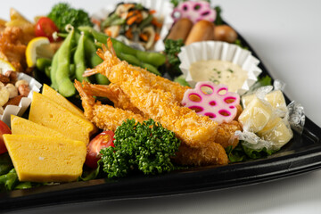 Delicious Japanese Bento Box with Crispy Fried Shrimp, Tamagoyaki, Edamame, and Fresh Vegetables
