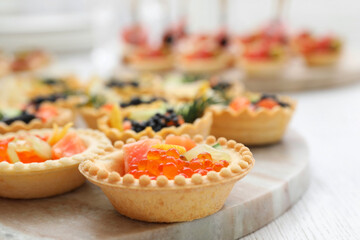 Many different tasty canapes on white wooden table, closeup