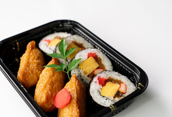 Close-Up of Sushi Rolls and Inari: A Platter Showcasing a Colorful Array of Maki Rolls with Various Fillings, Complemented by Flavorful Inari Sushi Pockets, Highlighting the Variety and Appeal of Japa