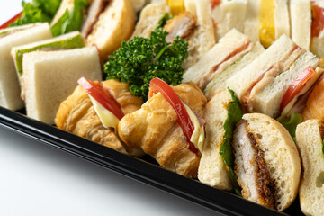 Close-Up of Delicious Sandwiches: A Platter Showcasing a Variety of Sandwiches with Visible Fillings Such as Egg Salad, Crispy Chicken Katsu, and Fresh Tomato Slices, Highlighting the Variety and Appe