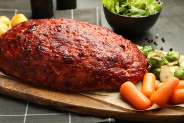 Delicious turkey meatloaf with vegetables on grey table, closeup
