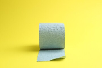 Light blue toilet paper roll on yellow background