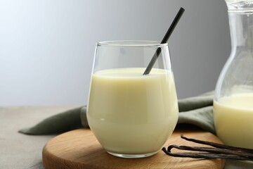 Delicious vanilla milk and pods on grey table