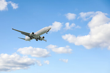 Airplane flying in beautiful blue sky with clouds