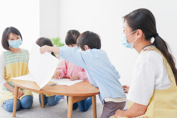 Obraz premium マスクをつけてお絵かきをする幼稚園児と先生