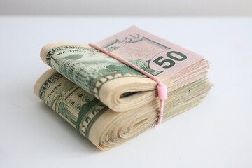 Two packs of 50 fifty dollar bills snug a rubber side view