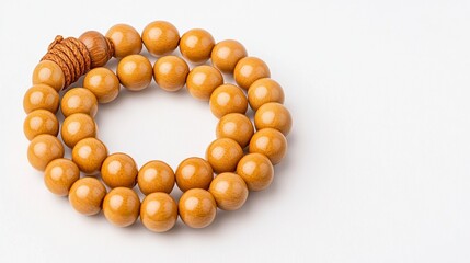 Obraz premium Circular arrangement of smooth wooden prayer beads with natural finish on plain white background