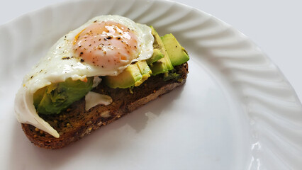 avocado toast topped with two fried eggs