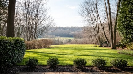 Obraz premium A serene landscape view featuring lush green grass, trees, and hills under a clear sky, inviting tranquility and nature's beauty.