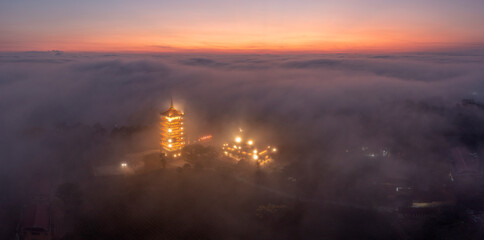 Naklejka premium The tower temple and the yellow flowers in front of the tower