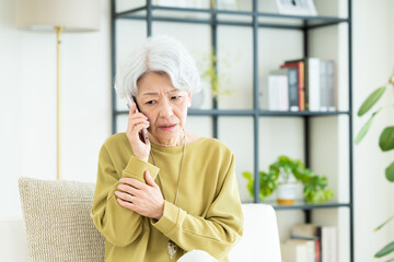 電話で驚くシニアの女性