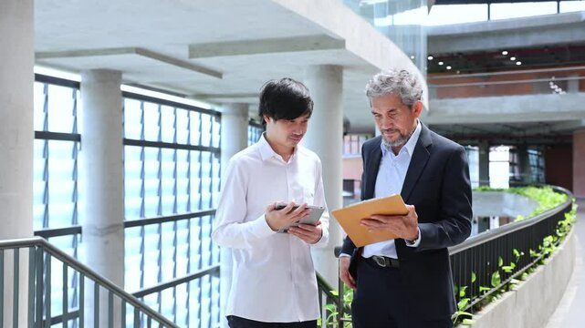 Asian senior professor is giving advice to the college student on the research thesis while sitting in the university faculty for education, academic and business	
