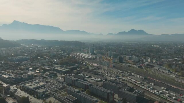 Salzburg Drone, Austria. Aerial View of Central Train Station and Cityscape and misty mountains