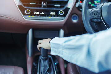 Business woman driver stick shift transmission a car gear, hand controlling steering wheel during...