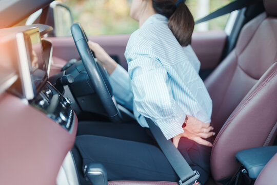 woman with her back sprain while driving car long time, back body ache due to Piriformis Syndrome, Low Back Pain and Spinal Compression. Ergonomic and medical concept
