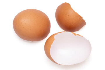 Brown egg shell broken or crack with pieces scattered on the surface.