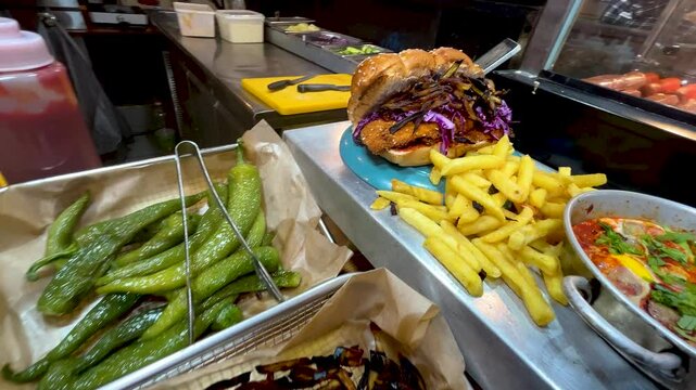 Shakshuka is a traditional Middle Eastern breakfast of eggs, peppers and tomatoes. Tel Aviv street food. French fries, peppers, a challah sabich sandwich with chicken schnitzel and eggplant.