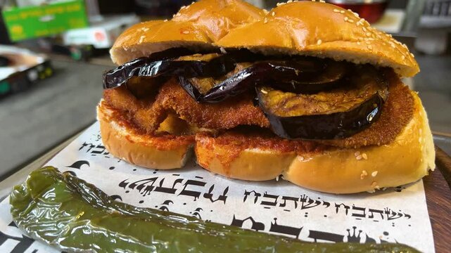 Challah sandwich with chicken schnitzel and eggplant, hummus and eggs. Traditional modern street food of Tel Aviv. Sabih Challah