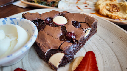 Delicious chocolate dessert served with fresh strawberries and cream