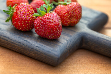 Ripe juicy strawberries on a wooden table. Healthy food rich in fiber, vitamins, antioxidants. Vegetarian food.