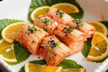 Korean food, Kimchi on white plate with lemon and herbs