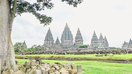 Straight angle view. the Prambanan temple, Central Java, Indonesia with Scattered solid masonry and a majestic trees