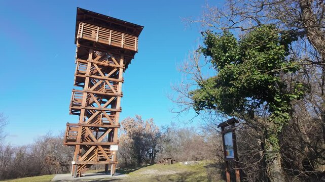Footage of the wooden observation tower at Kecskehegyi Lookout, located near Sopron, Hungary, with a clear sky and scenic views of the surrounding landscape.