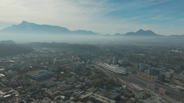 Salzburg Drone, Austria. Aerial View of Central Train Station and Cityscape and misty mountains