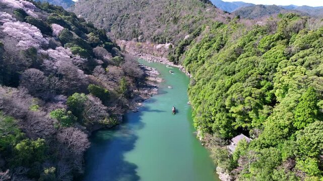 Boatman punting the boat at river. Arashiyama in spring season along the river in Kyoto, Japan.