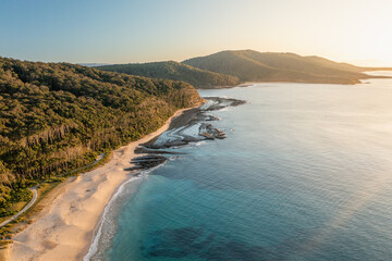 Golden Sunrise Over a Tranquil Beach – Stunning Aerial Drone View of Waves, Sand, and Morning Light