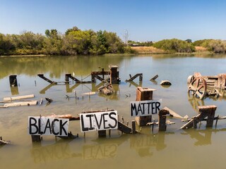 Rusty shipwrecked remains in the Bolinas Lagoon waterway, protesting Black Lives Matter. Stinson...