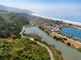 Coastal road winds along the Bolinas Loagoon with Stinson Beach, park and homes visible. Marin County , San Francisco, California, USA