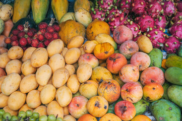assortment of fresh Asian exotic tropical fruits and mangoes on the counter at Asian street market in Thailand