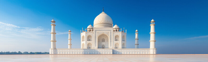 Taj Mahal's Majestic Reflection: The Taj Mahal stands in serene majesty against a vivid blue sky, its immaculate white marble reflecting elegantly in the still waters below.