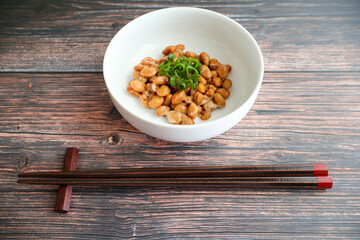 木製テーブルの上に置いた納豆と箸