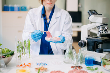 Fototapeta premium Scientist testing food samples in lab with microscope, vegetables, and meat for safety, nutrition, and biotechnology