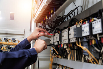 Checking the electrical system, an electrician is using an electric meter to check the electrical...