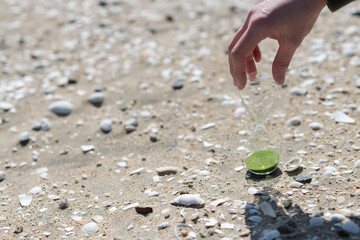 砂浜で砂時計を持っている人