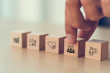 Employee benefits concep. Wooden blocks with icons representing various employee benefits,...