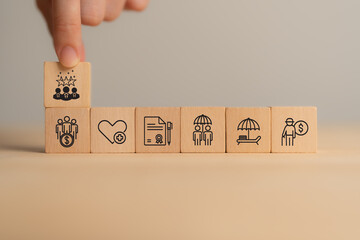 Employee benefits concept. A hand stacking wooden blocks with icons representing various employee benefits, including financial security, health insurance, retirement planning, and vacation time.