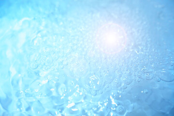 Bubbles and seething water in the light of sunlight.Blue water texture.