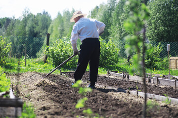 The farmer is digging a garden. A man with a harvester plows the garden. The gray-haired grandfather mows the garden.
