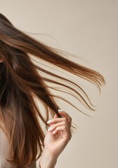 Slender brunette with white tipped nails softly caressing flowing locks, embodying graceful movement against neutral background