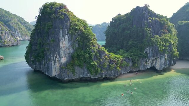 Aerial view of Halong Bay in Northern Vietnam. People swim to the hidden beach.