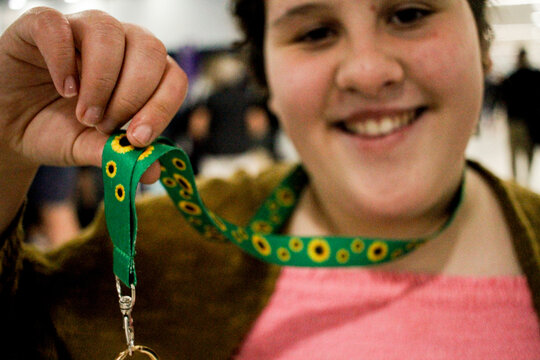 Teen with disability wearing a sunflower lanyard at an airport