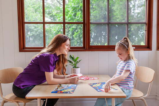 Child with speech disability looking at sound cards talking with speech-language pathologist