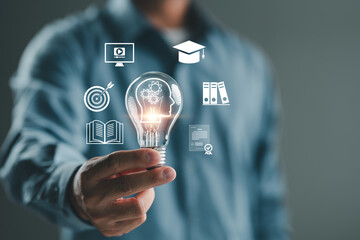 Man hand holding lightbulb with learning educate and graduation concept. Study knowledge to...