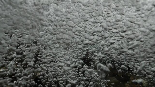 bubbles underwater makes shapes in fast flowing river fresh water