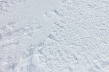 A snow covered ground with a few footprints